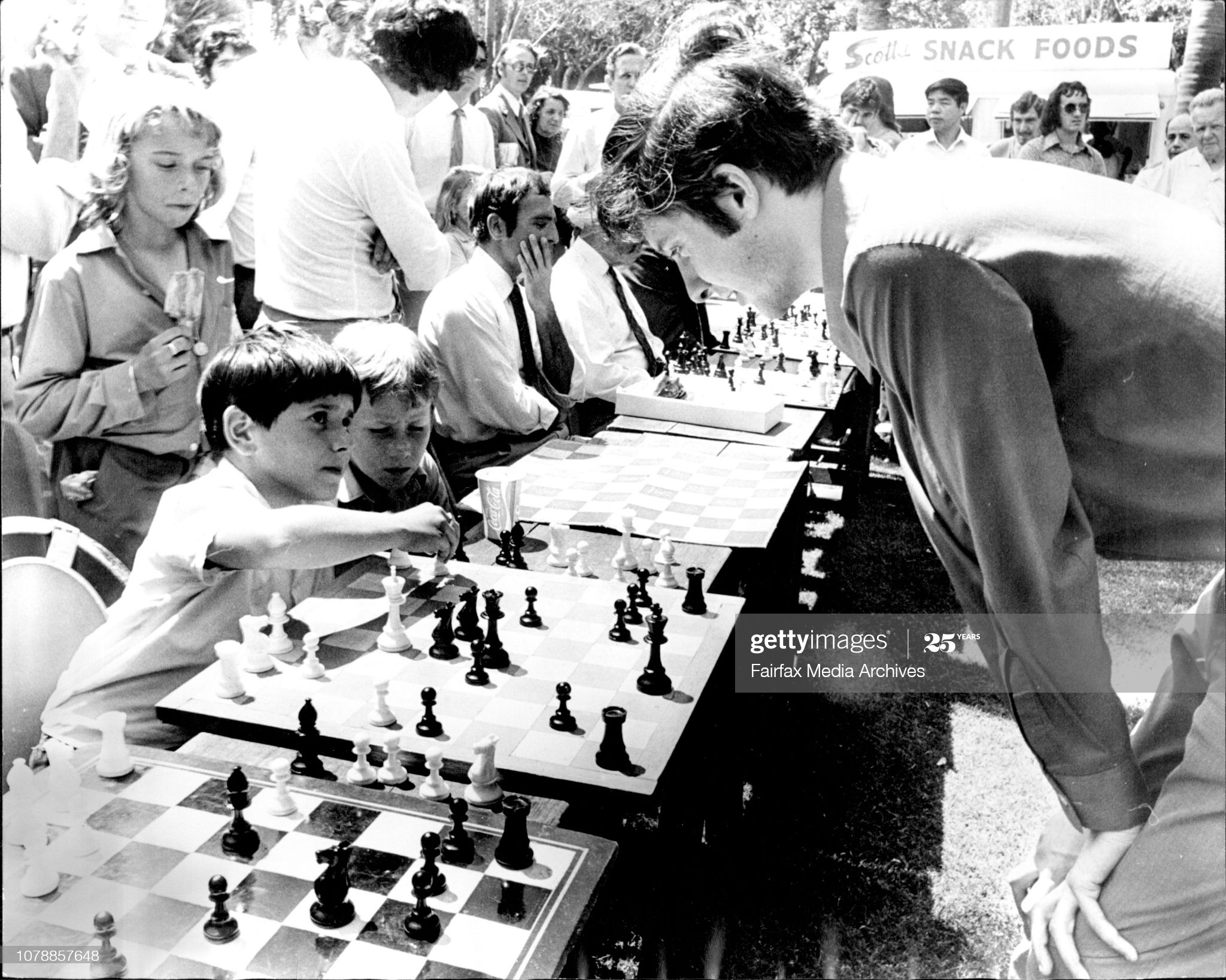 Aleandro Trimboli (10) of Leichhardt plays Mr Max Fuller of Newtown, Australian Open Chess Champion. As part of the Waratah Festival Celebrations the NSW Chess Association is conducting chess games with chess champions playing up to 30 players at once, in Hyde Park. October 17, 1973. (Photo by Golding/Fairfax Media via Getty Images).