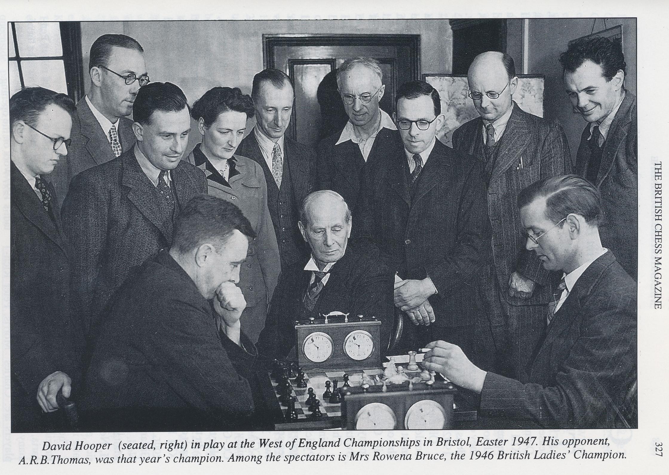 David Hooper (seated right) in play at the West of England Championships in Bristol, Easter, 1947. His opponent , ARB Thomas , was that year's champion. Among the spectators is Mrs. Rowena Bruce, the 1946 British Ladies' Champion. BCM, Volume 118, #6, p.327. The others in the photo are L - R: H. V. Trevenen; H. Wilson-Osborne (WECU President); R. A. (Ron) Slade; Rowena Bruce; Ron Bruce; H. V. (Harry) Mallison; Chris Sullivan; C. Welch (Controller); F. E. A. (Frank) Kitto.