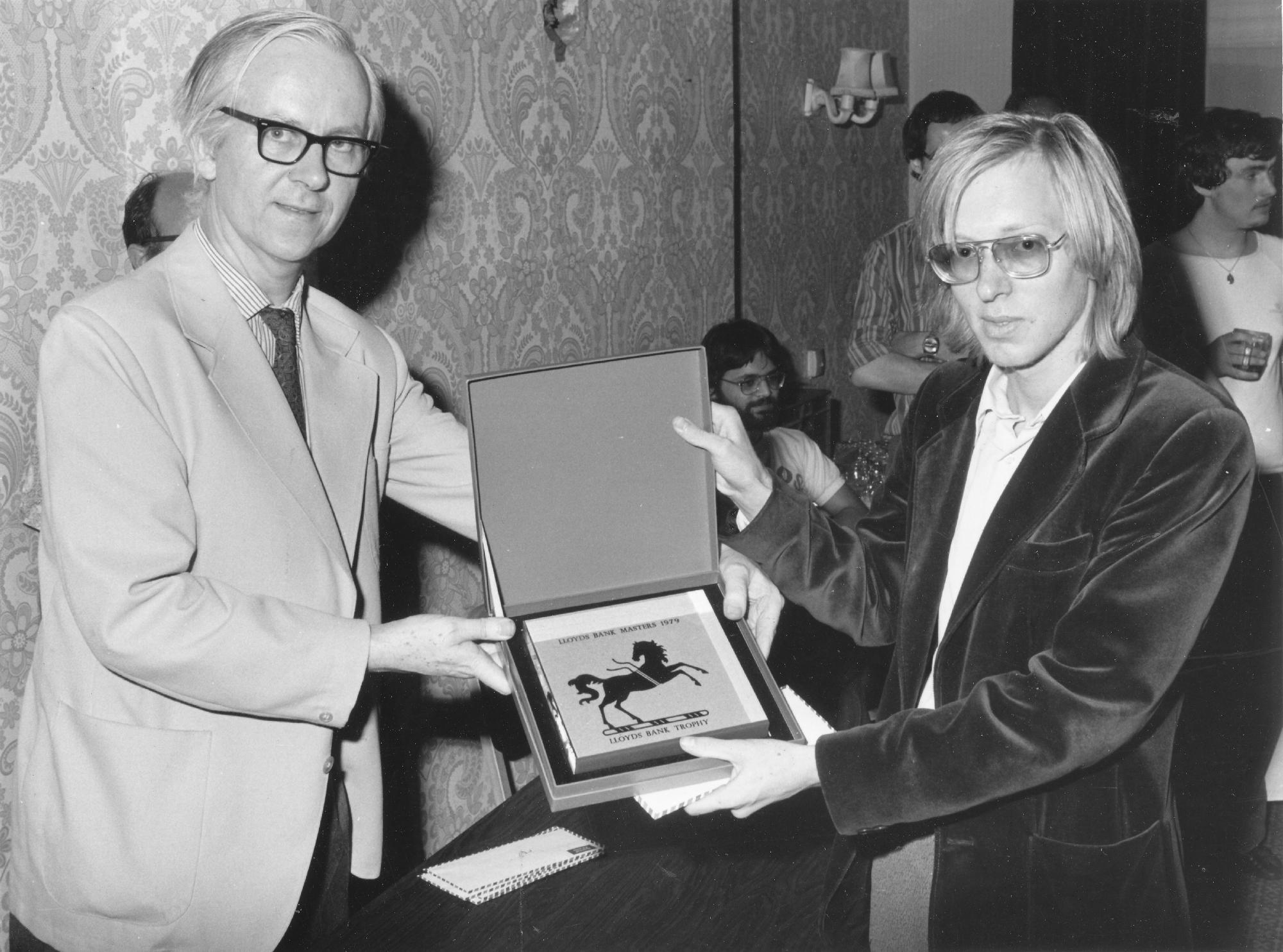 Leonard Barden (left) and Murray Chandler display the Lloyds Bank Trophy which the 19-year old New Zealander won ahead of 3 Grandmasters and 10 International Masters for his finest international success up to 1979. in the Lloyds Bank Masters