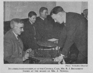 In simultaneous play at the central cafe, Mr. RJ Broadbent pauses at the board of Mr. J. Nowell, original source : The Yorkshire Observer