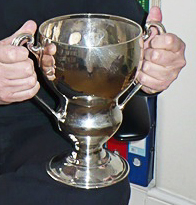 The Felce Cup held by the hands of Stephen Moss in 2014