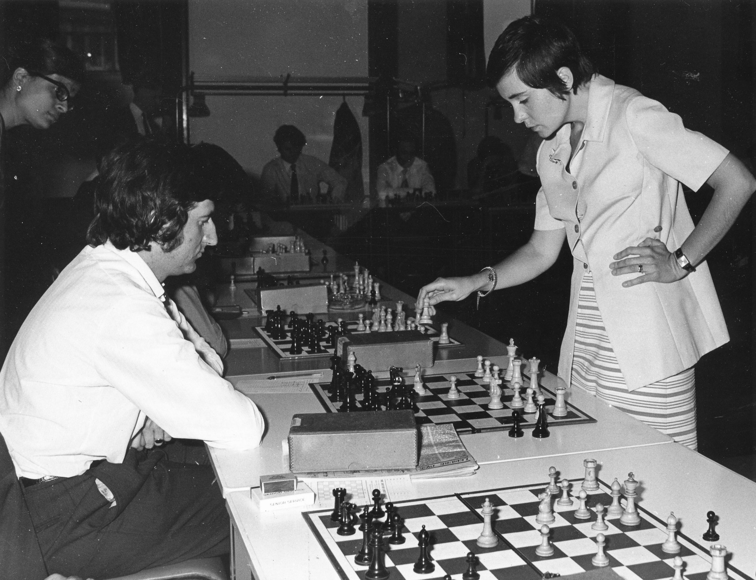 Moment of concentration for reigning women's champion of Great Britain Jana Hartston and some of the 30 Post Officer players - all men who challenged her at postal headquarters London on September 6. Jana beat seven, drew with sixteen and lost to seven.