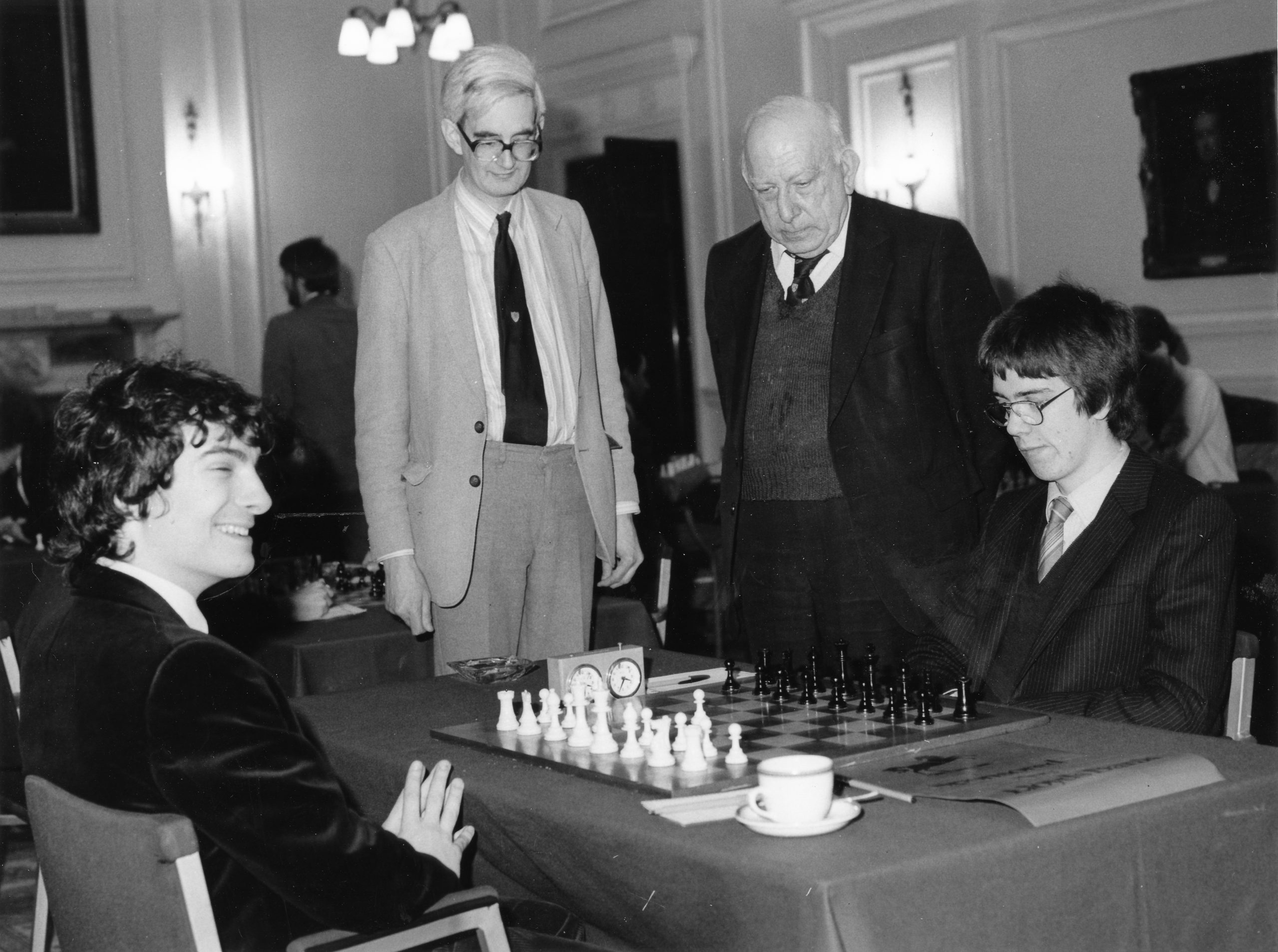 Adrian Hollis and Harry Golombek observer Andrew Dyson (Trinity) having played 1.d4 versus IM William Watson (Merton) during the 1984 Varsity match sponsored by Lloyds Bank