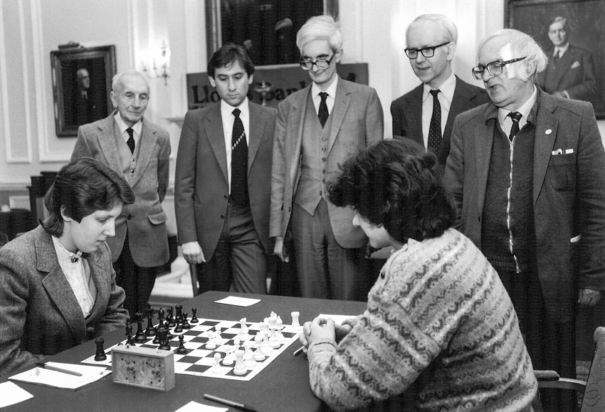 From the 1985 Varsity Match : Laura Cohen (Newnham), Brian Reilly (BCM), Bill Hartston (Cambridge), Adrian Hollis (Oxford), Anita Rakshit (St. Hilda's), Leonard Barden (The Guardian etc) and Bob Wade (BCF)